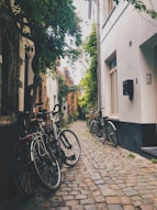 black bicycle parked beside white concrete building during daytime