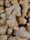 A close-up view of several ginger roots with rough, light brown skin and knobby surfaces.