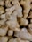 A close-up view of several ginger roots with rough, light brown skin and knobby surfaces.