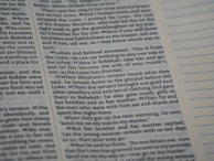 A close-up view of a page from a book with printed text in English. The passage appears to be from a religious or historical context, focusing on a dialogue involving Laban, Bethuel, and Abraham’s servant. The text is arranged in paragraphs with verse numbers in bold. Blank lined sections are visible on the opposite page.