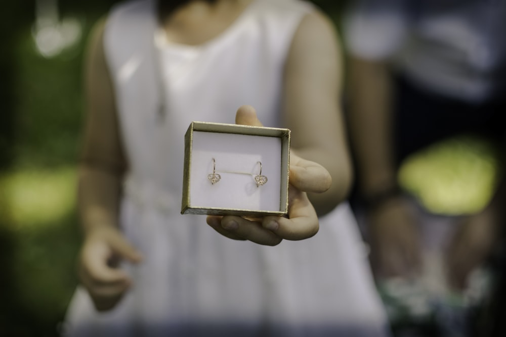 woman in white tank top holding gold photo frame