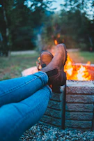 Boots resting beside a campfire under a starry night sky.
