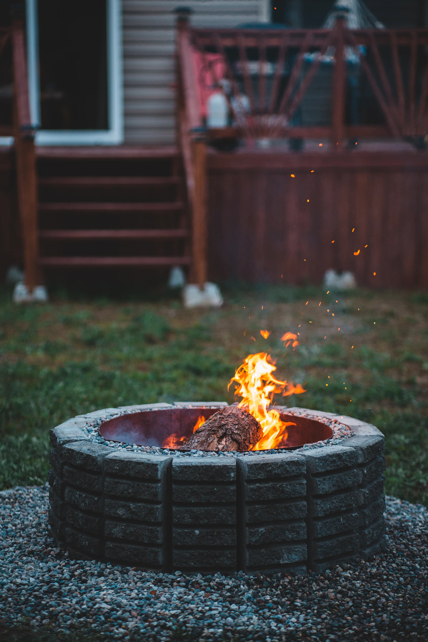 Outdoor fire pit with active flame in a backyard setting