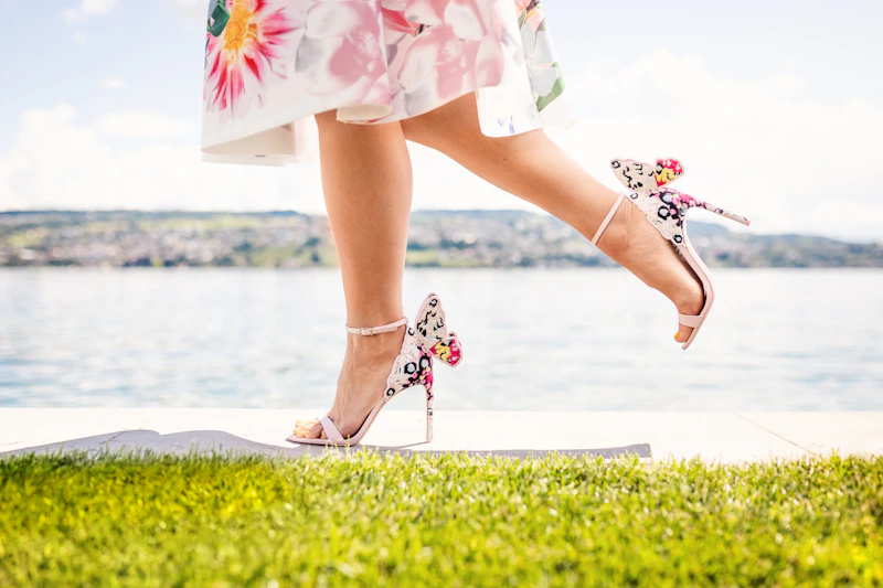woman in a floral dress standing on green grass
