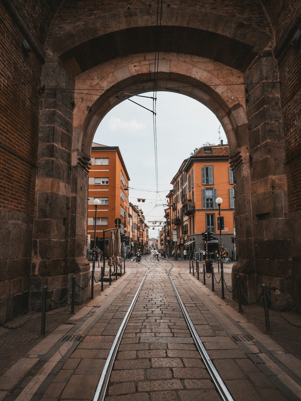 Personas caminando por la acera cerca de un edificio de hormigón marrón durante el día