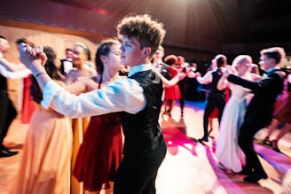 man in black suit standing on stage