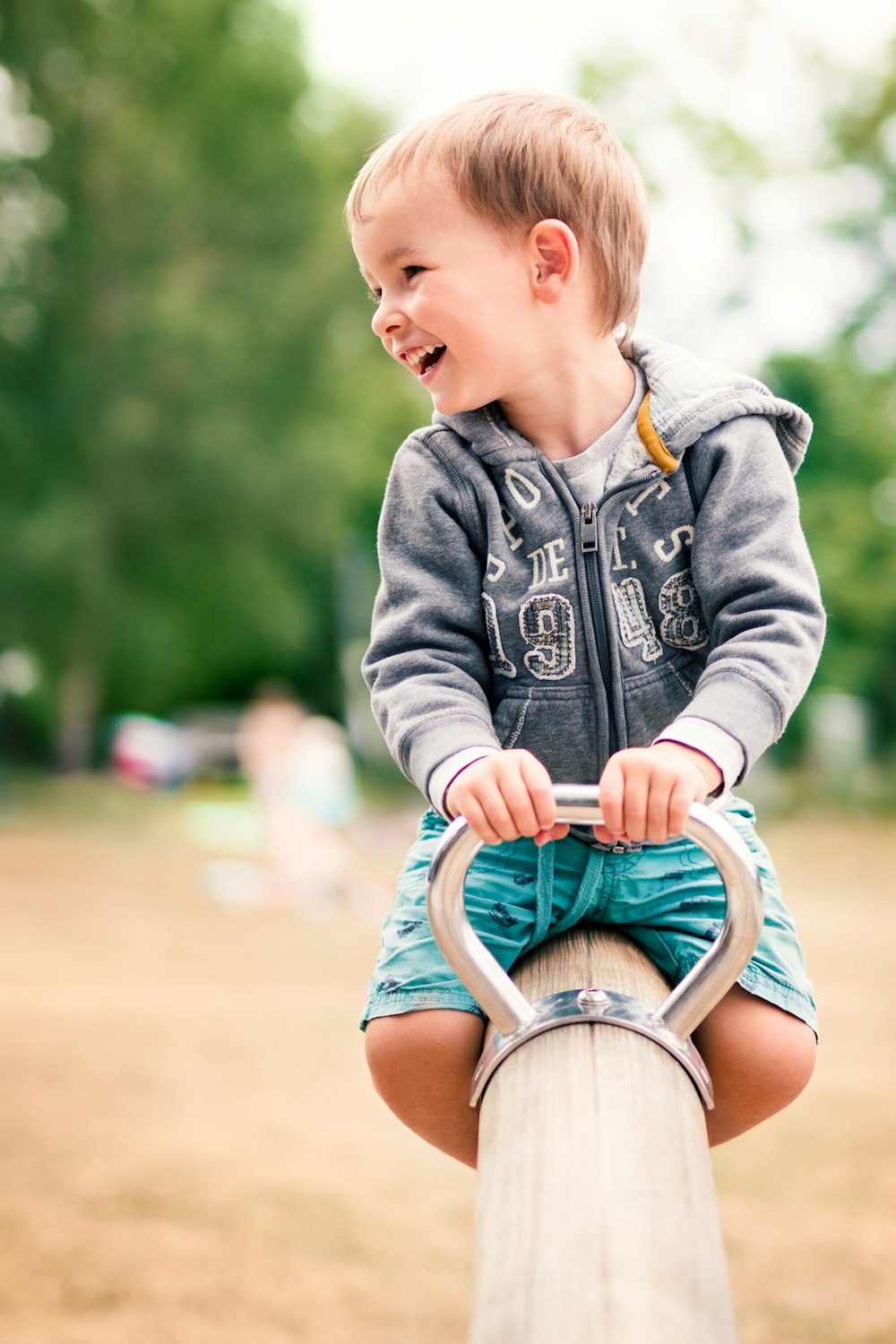 bébé en veste en jean bleu assis sur une chaise en bois marron pendant la journée