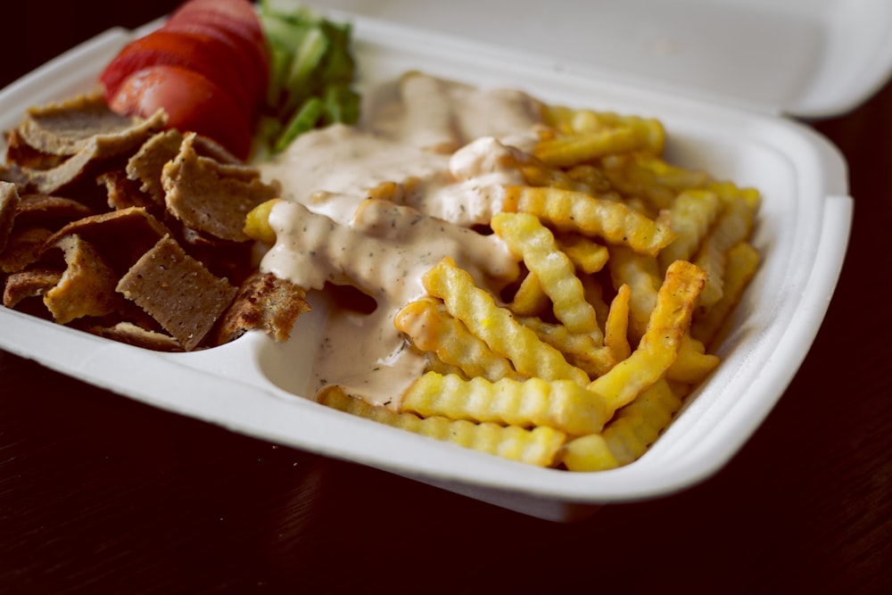 fries and meat on white ceramic plate