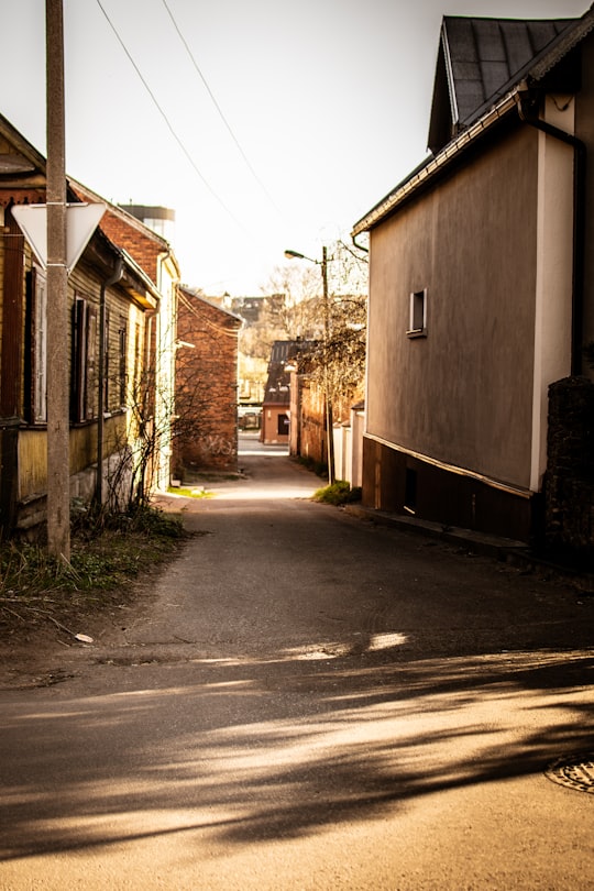 empty street in between houses during daytime in Kaunas Lithuania