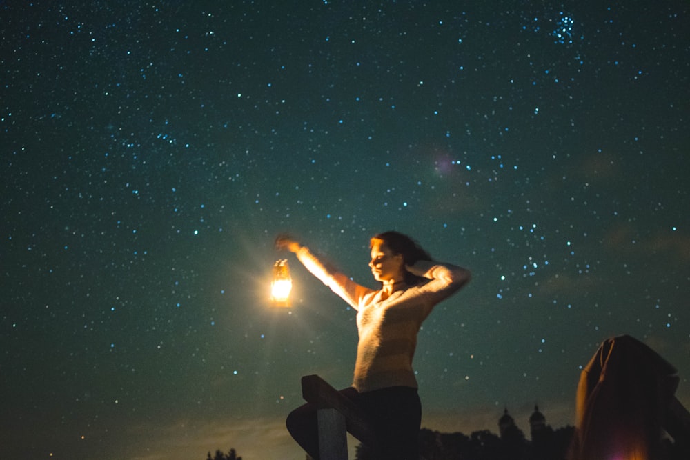 man in black shorts sitting on rock during night time