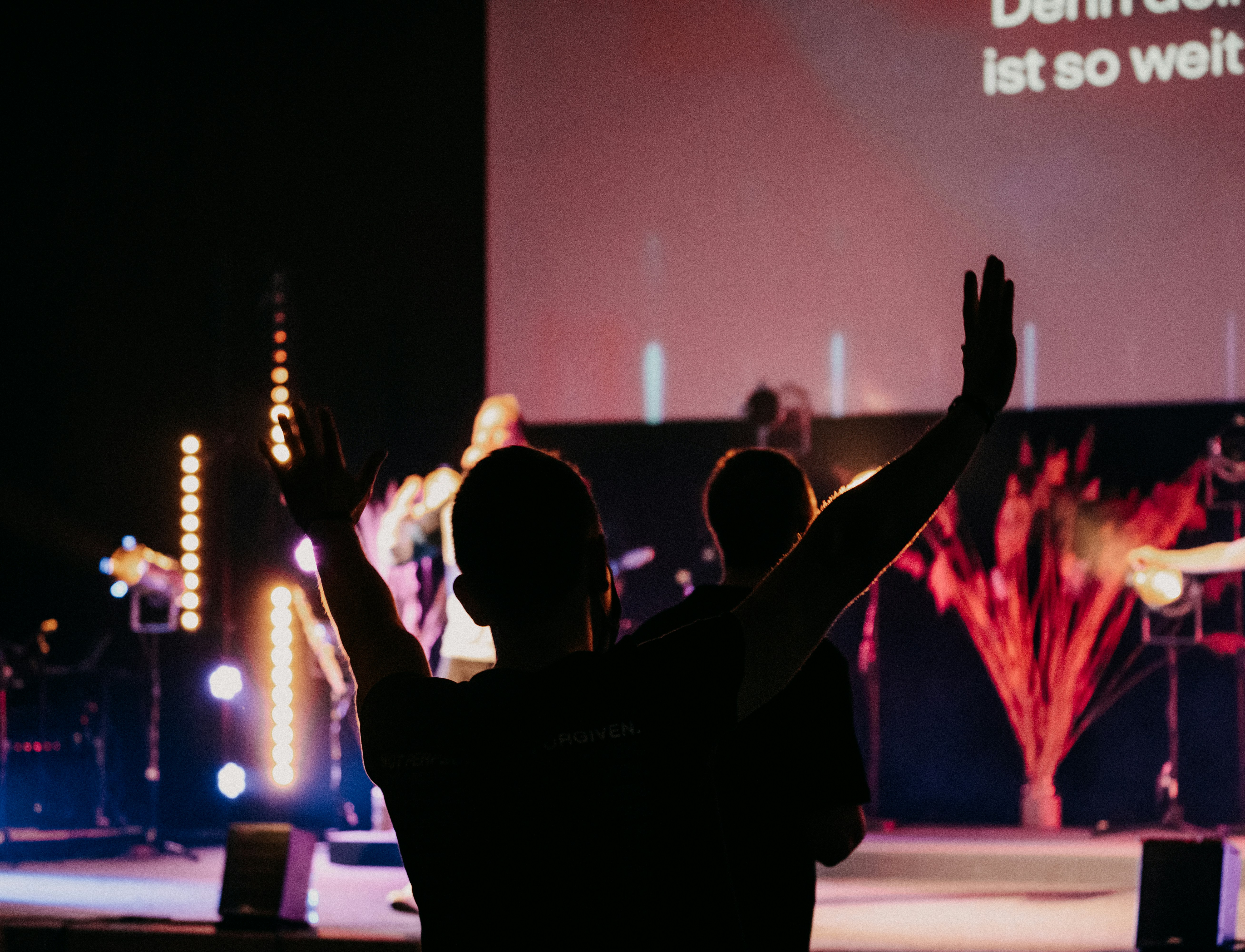 homme en t-shirt noir levant les mains