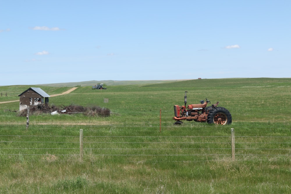 red tractor on green grass field during daytime