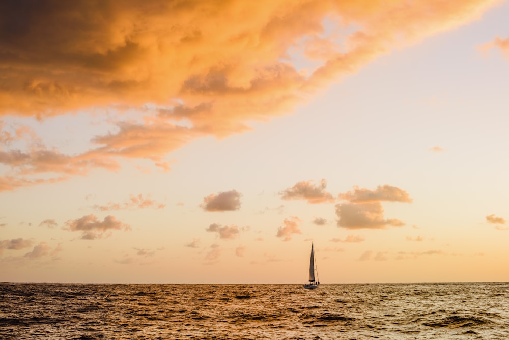 Segelboot auf See unter bewölktem Himmel tagsüber