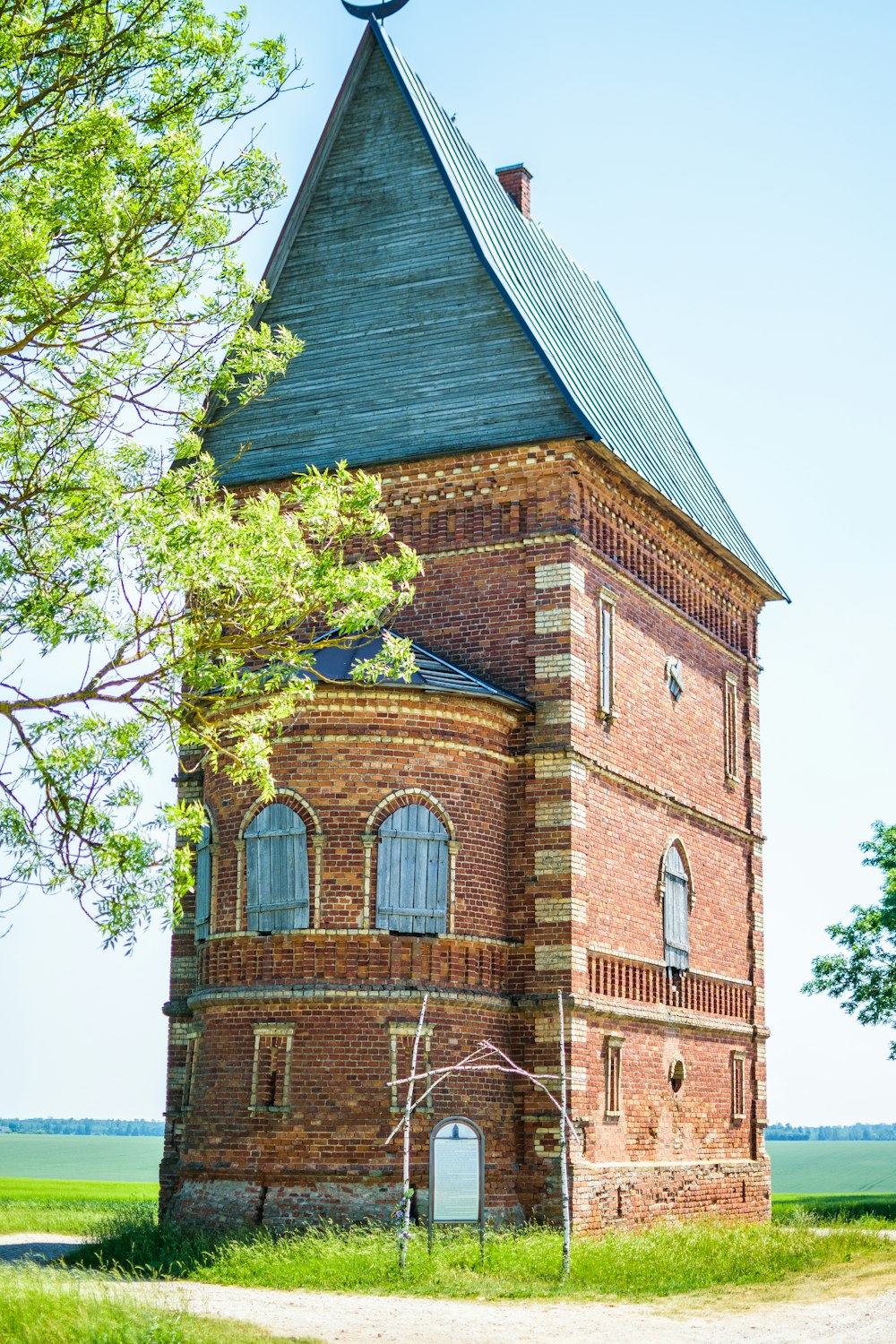 brown brick building near green tree during daytime