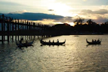 Sunset view over a calm river with silhouettes of rafters preparing their gear