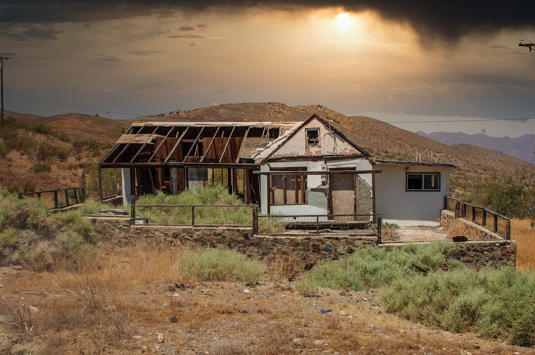 white and brown house near green grass field during daytime