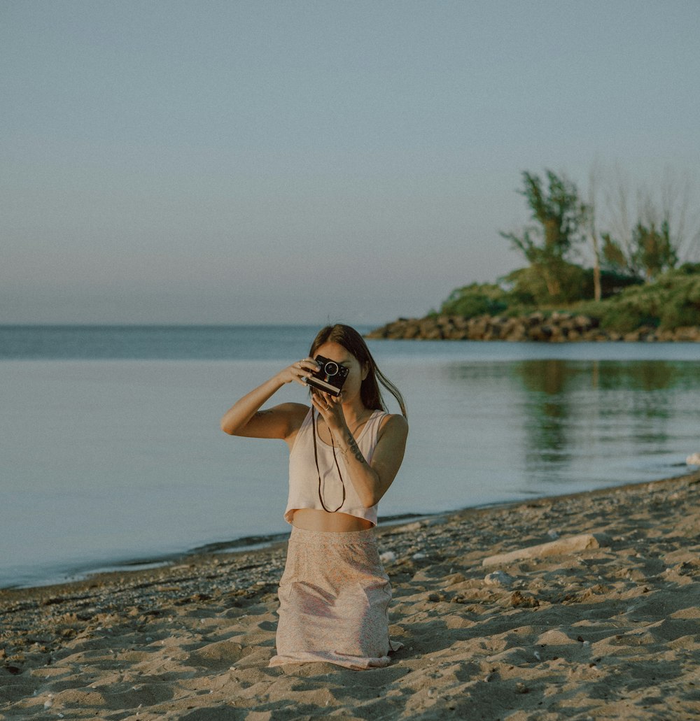 woman in white dress standing on beach during daytime