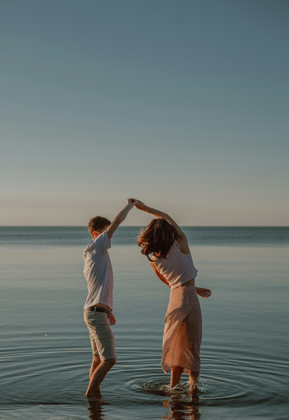 man and woman standing on seashore during daytime