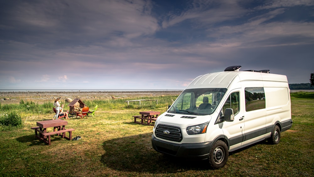 white van on green grass field during daytime