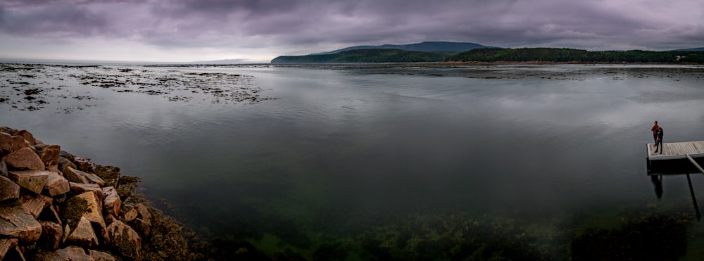 green island on body of water under cloudy sky