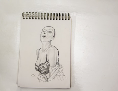 A detailed pencil sketch of a seated woman, highlighting delicate shading and anatomy.