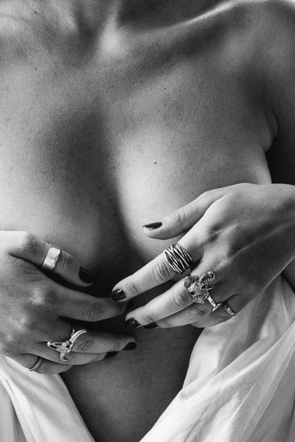 grayscale photo of person wearing rings