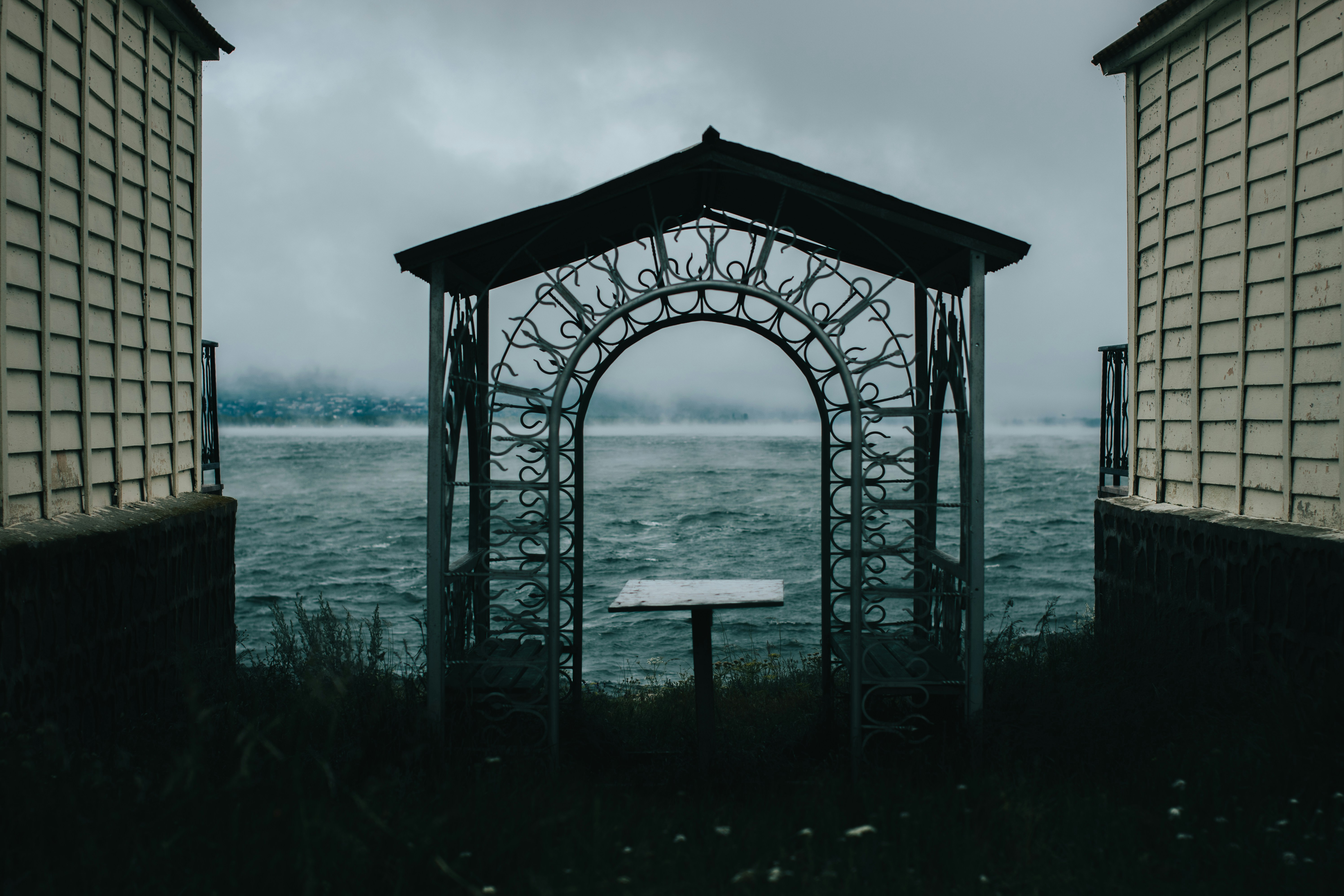 Brown wooden gazebo on body of water during daytime