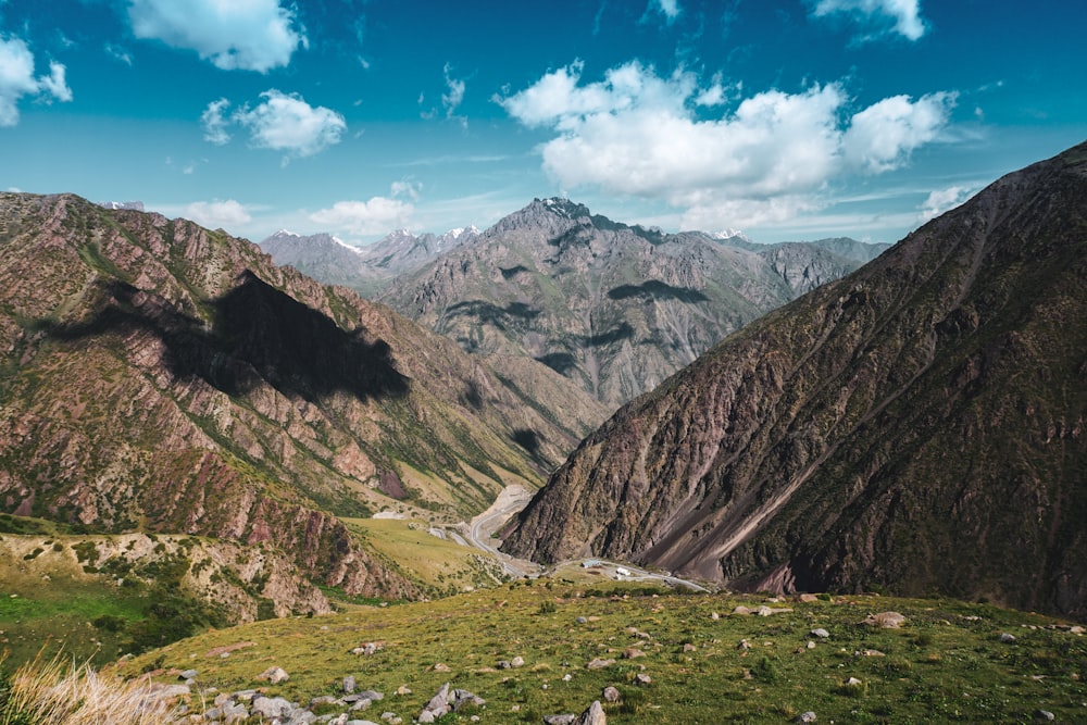 montagnes vertes et brunes sous le ciel bleu pendant la journée