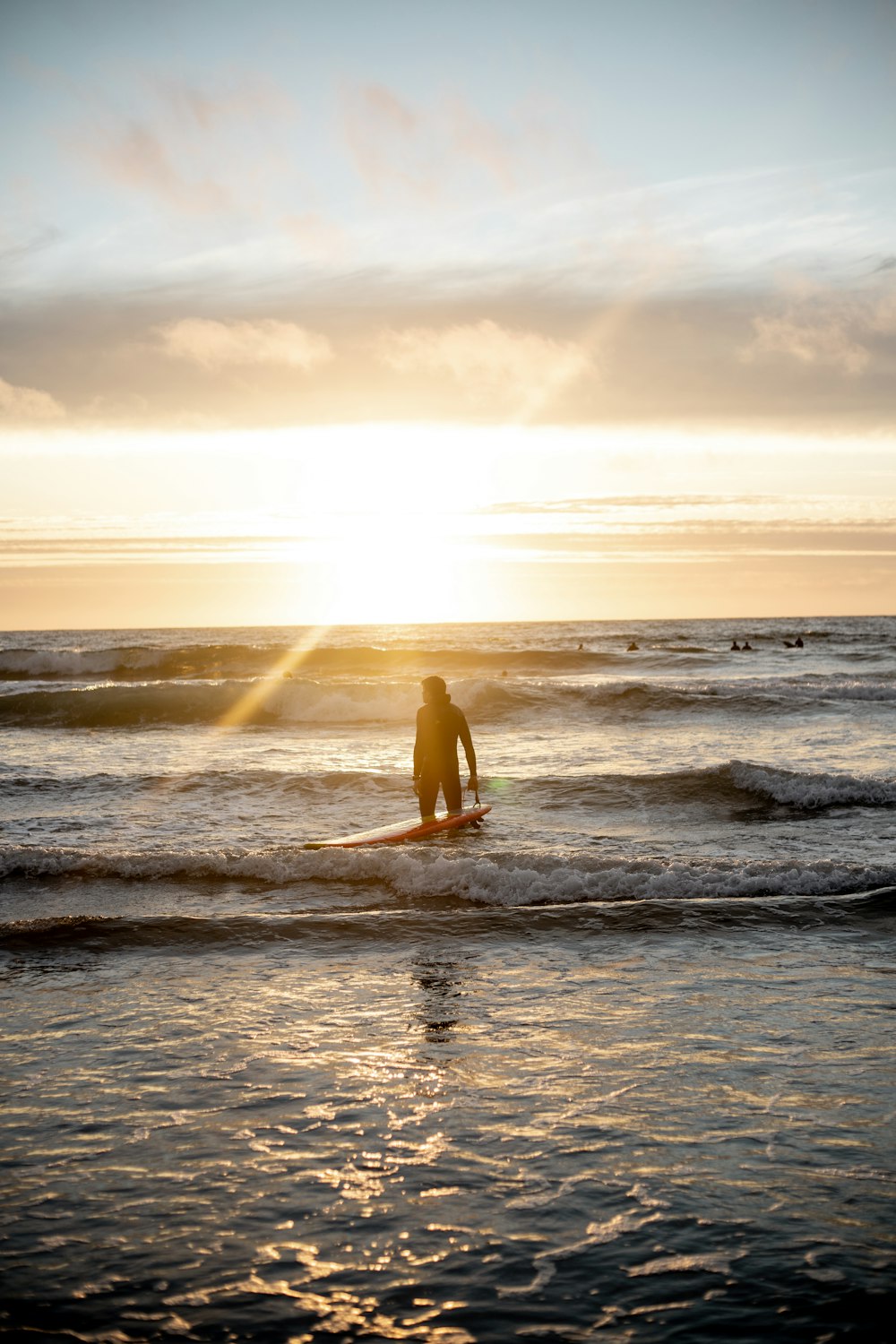 Persona che fa surf sulle onde del mare durante il tramonto