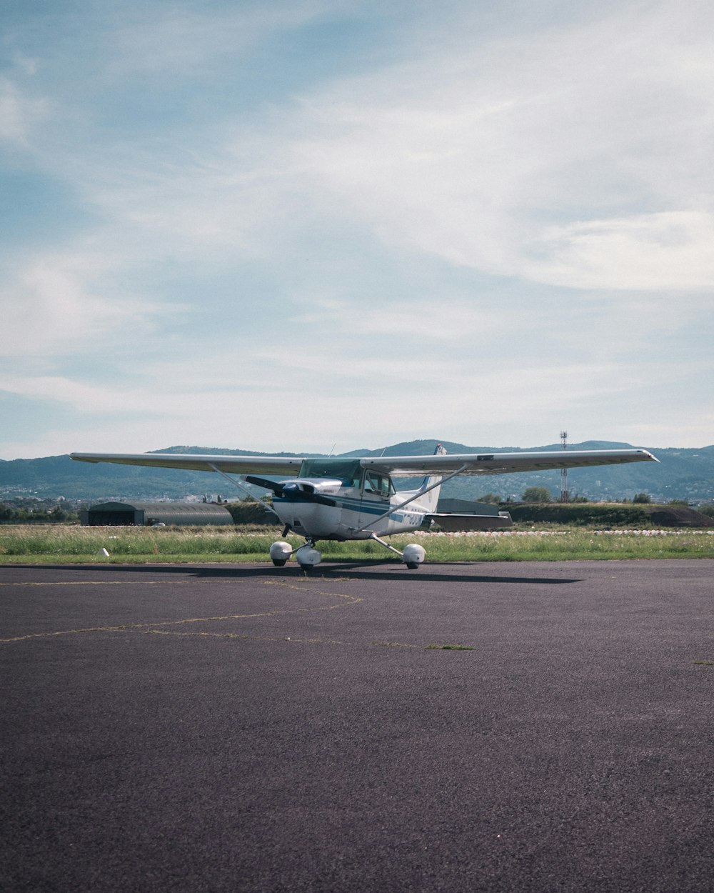 white airplane on gray concrete ground under white clouds during daytime