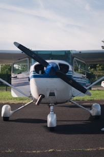 white and blue airplane on gray asphalt road during daytime