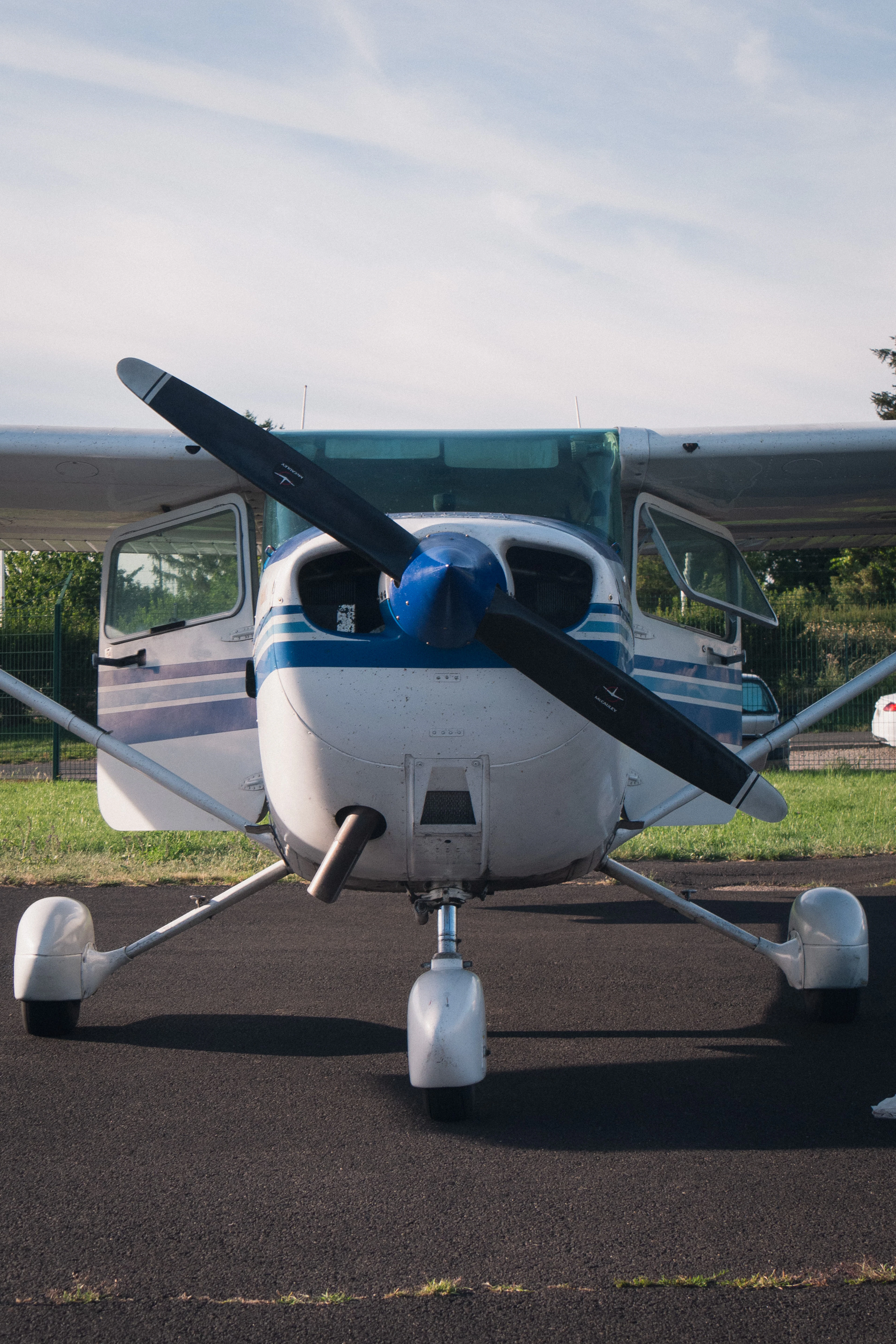 Front view of a blue and white Cessna on the apron