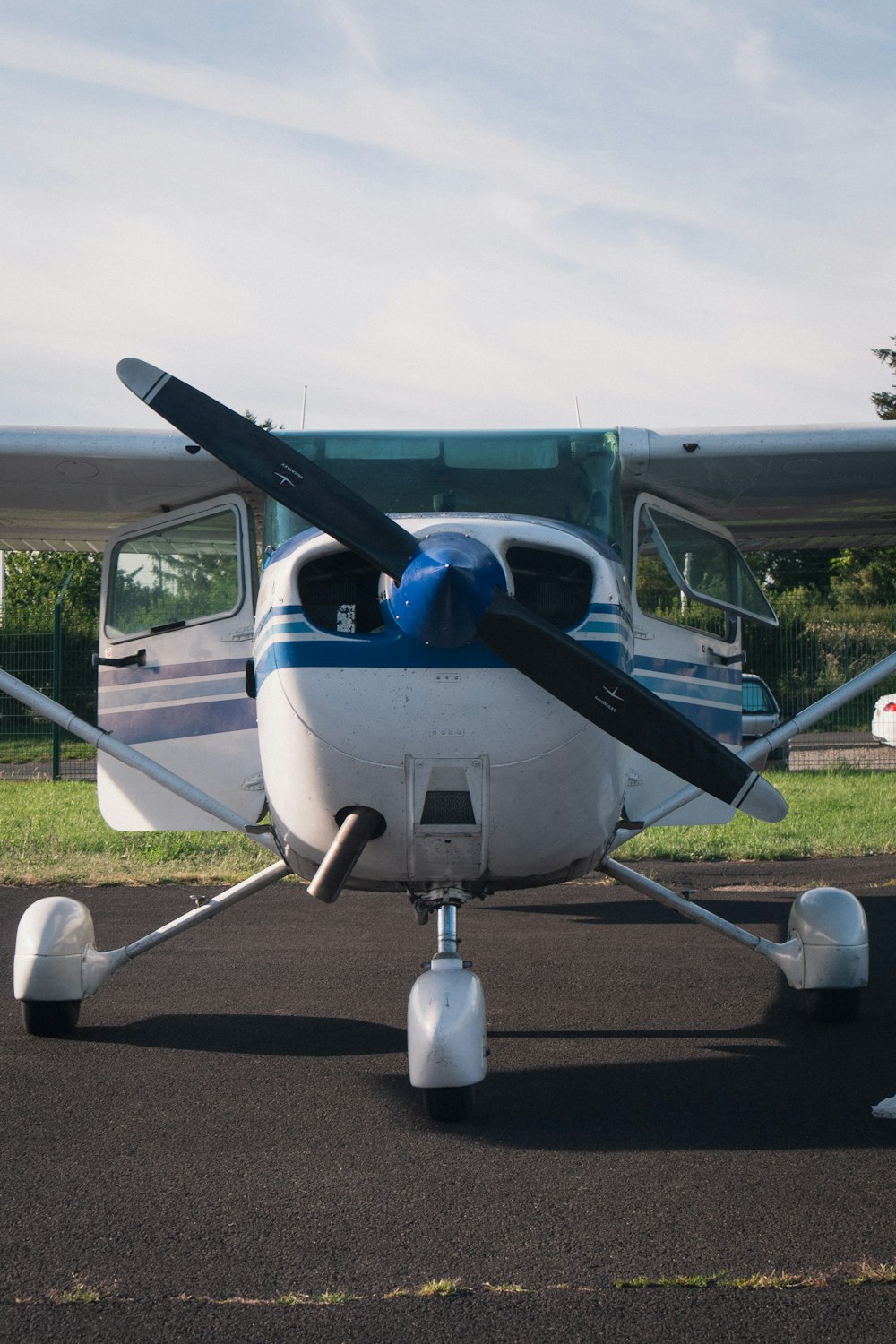 white and blue airplane on gray asphalt road during daytime