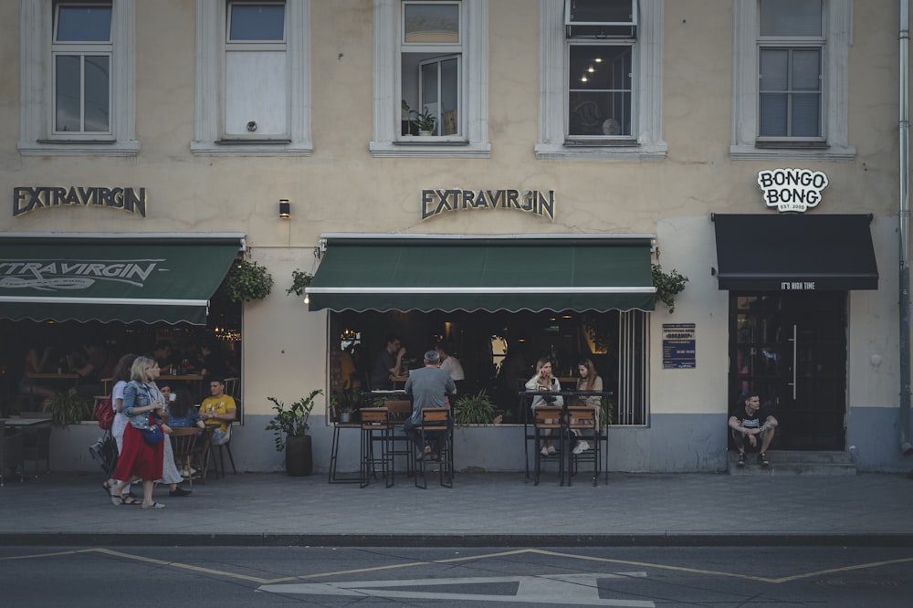 people sitting on chairs outside the building during daytime