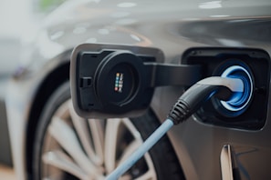 Technician aligning wheels beside an electric vehicle, showcasing precise service next to charging units.