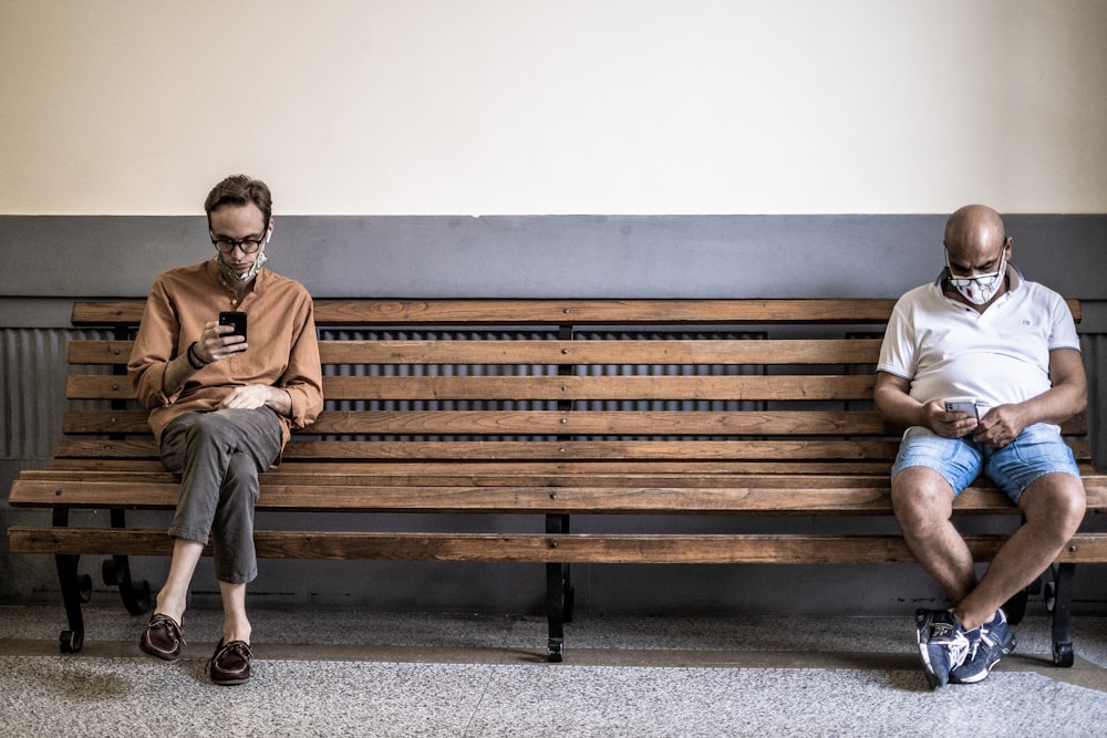 man in brown dress shirt sitting on brown wooden bench