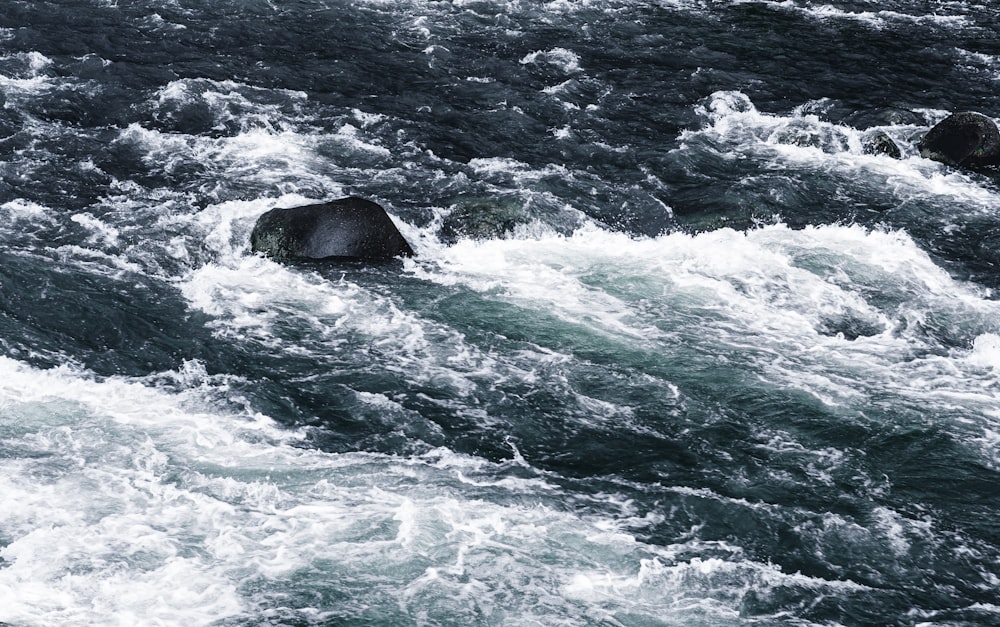 ocean waves crashing on rocks during daytime