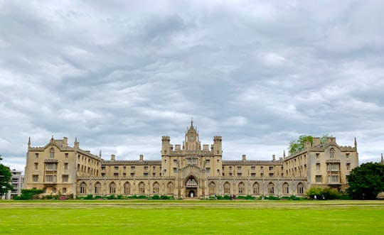 green grass field near brown concrete building under white clouds during daytime in St John's College United Kingdom