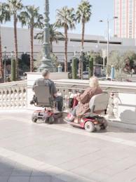 woman in gray jacket riding red and black motor scooter during daytime
