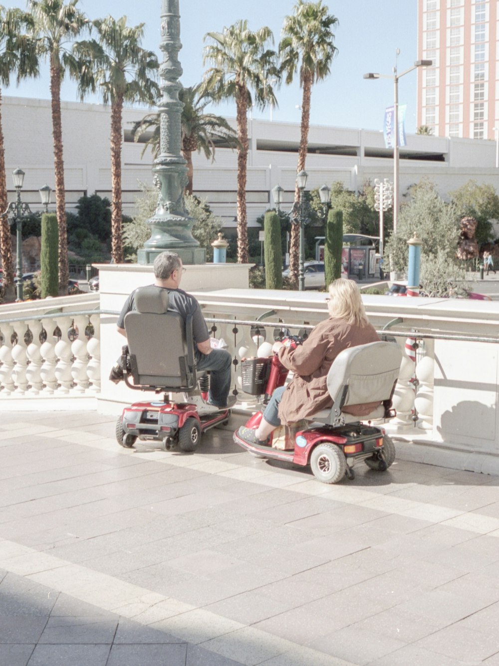 woman in gray jacket riding red and black motor scooter during daytime