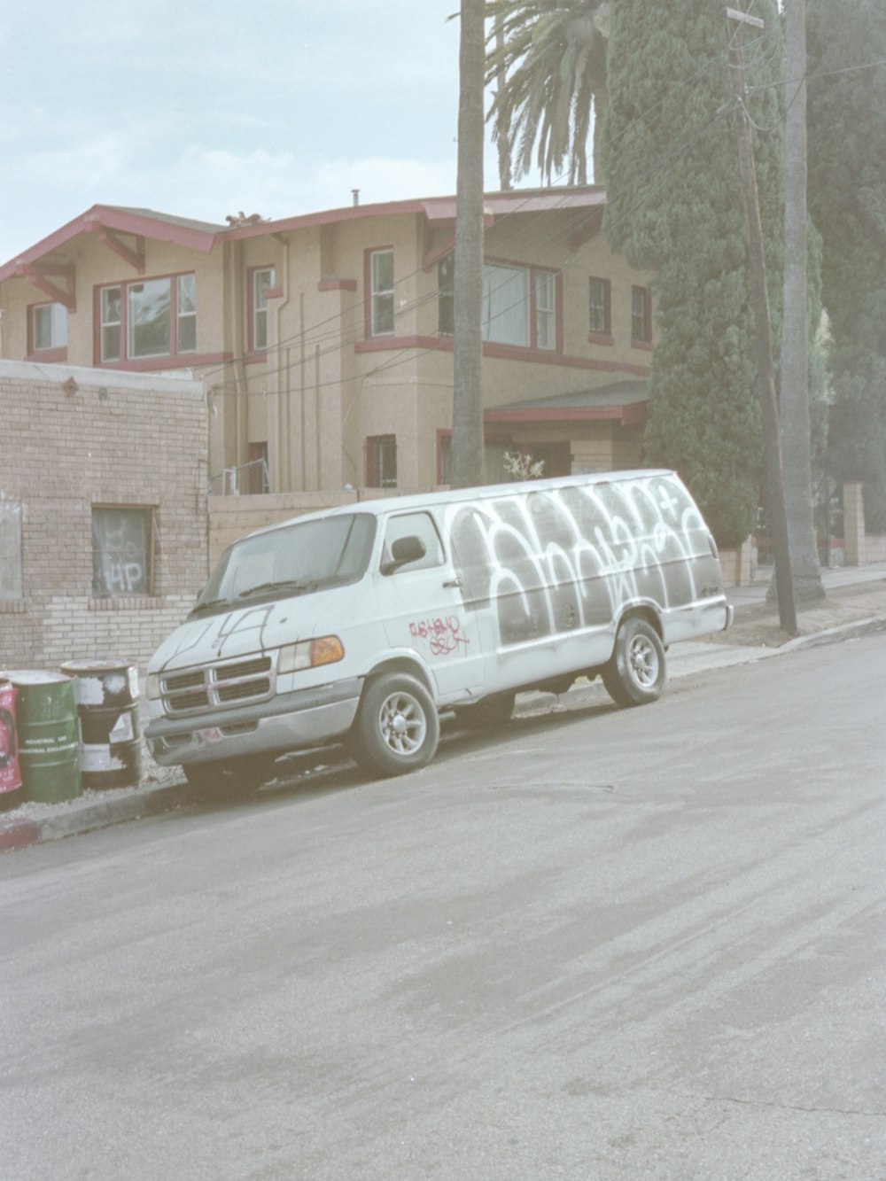 white van parked beside brown building during daytime