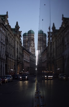 cars parked on side of road in front of brown concrete building during daytime