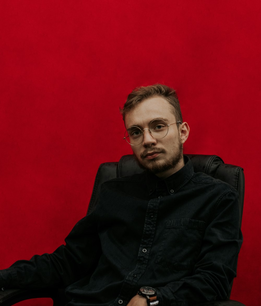 man in black jacket sitting on chair