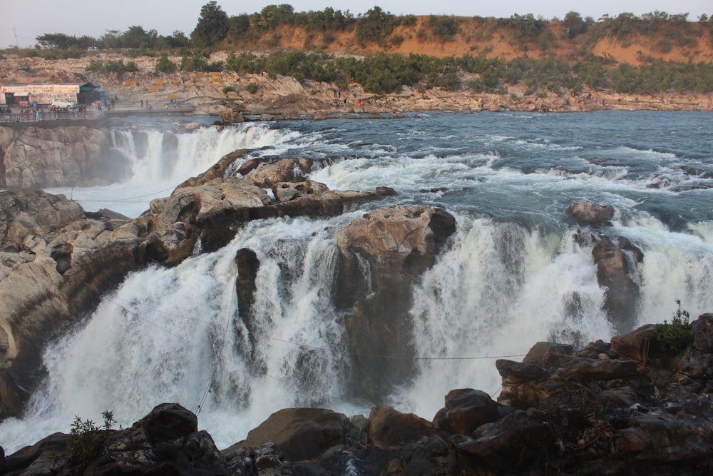 brown rock formation on body of water during daytime