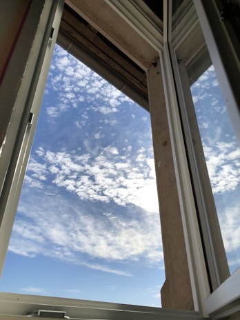 Close-up of a sparkling clean window reflecting a bright blue sky.