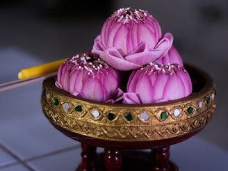 pink and yellow flower on brown wooden table
