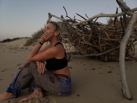 Benita standing on a windswept beach, gazing thoughtfully at the horizon.