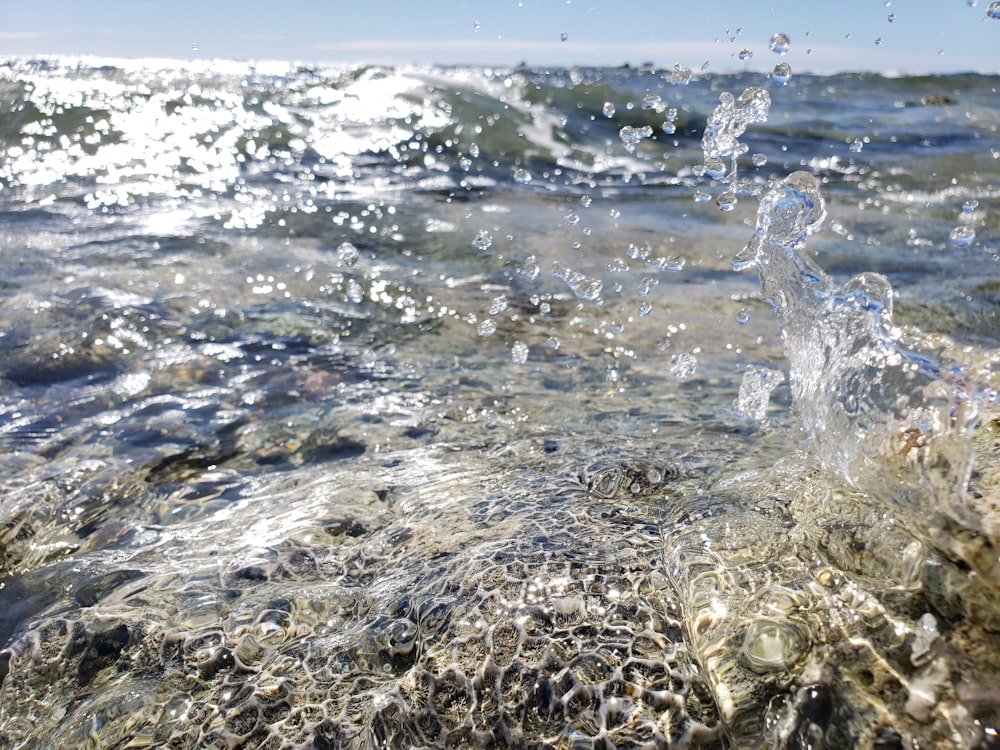 water splash on brown sand during daytime