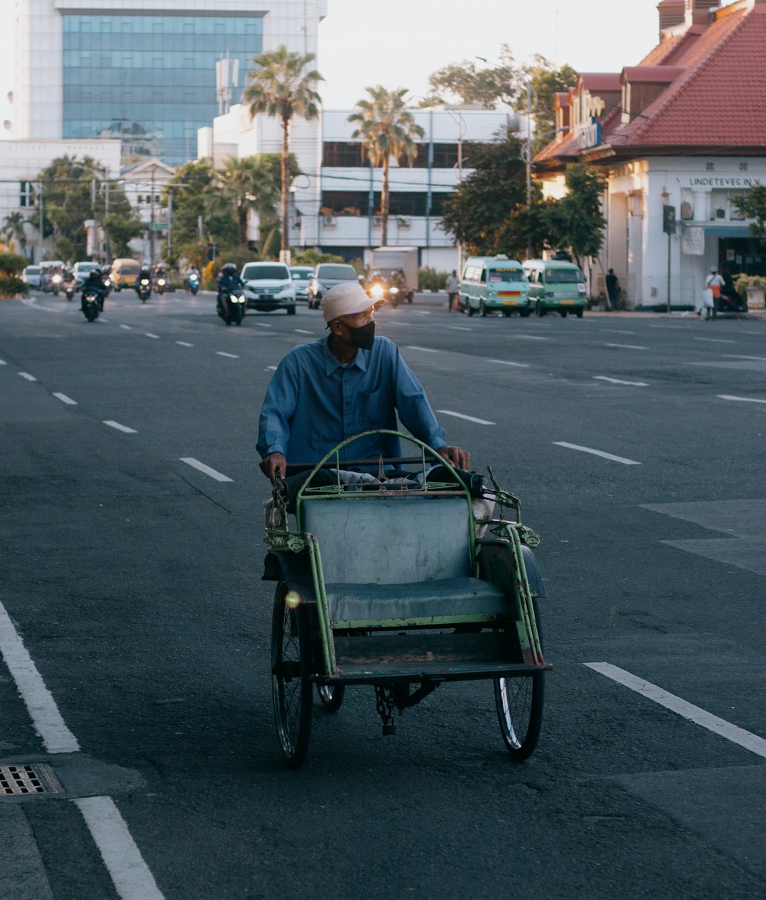 man in blue polo shirt riding green cart on road during daytime