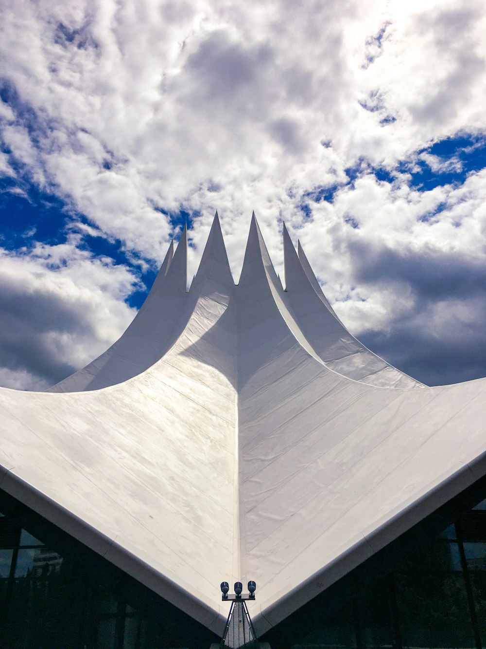 white concrete building under white clouds and blue sky during daytime